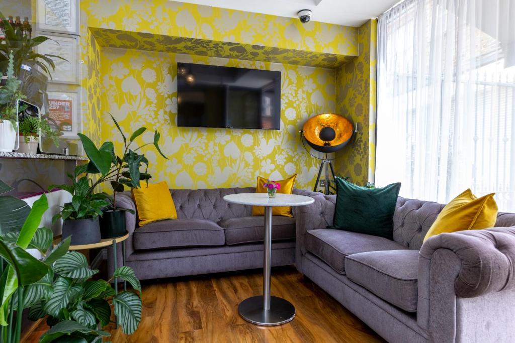 a living room with a couch and a table at Hotel Shepherds Bush London in London