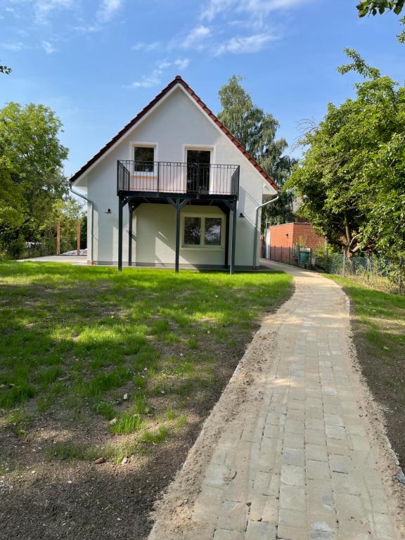 een huis met een veranda en een oprit bij Belthus in Fehmarn