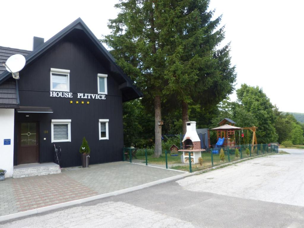 un edificio negro con un patio de juegos delante de él en House Plitvice, en Lagos de Plitvice