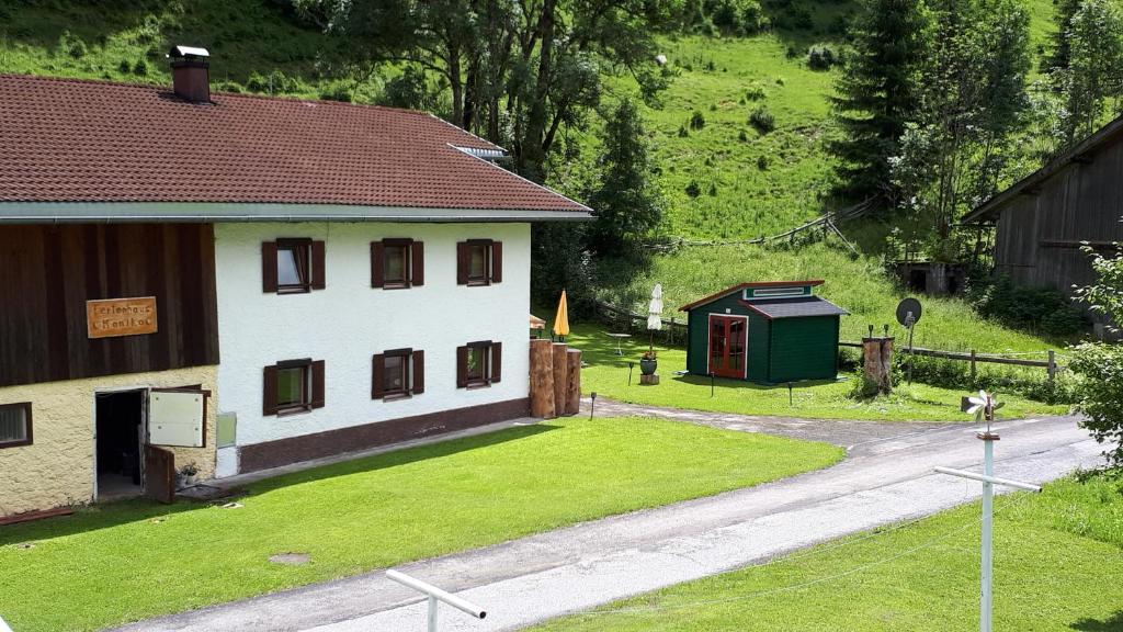 una casa con un patio de césped junto a una carretera en Ferienhaus Monika en Gutschau