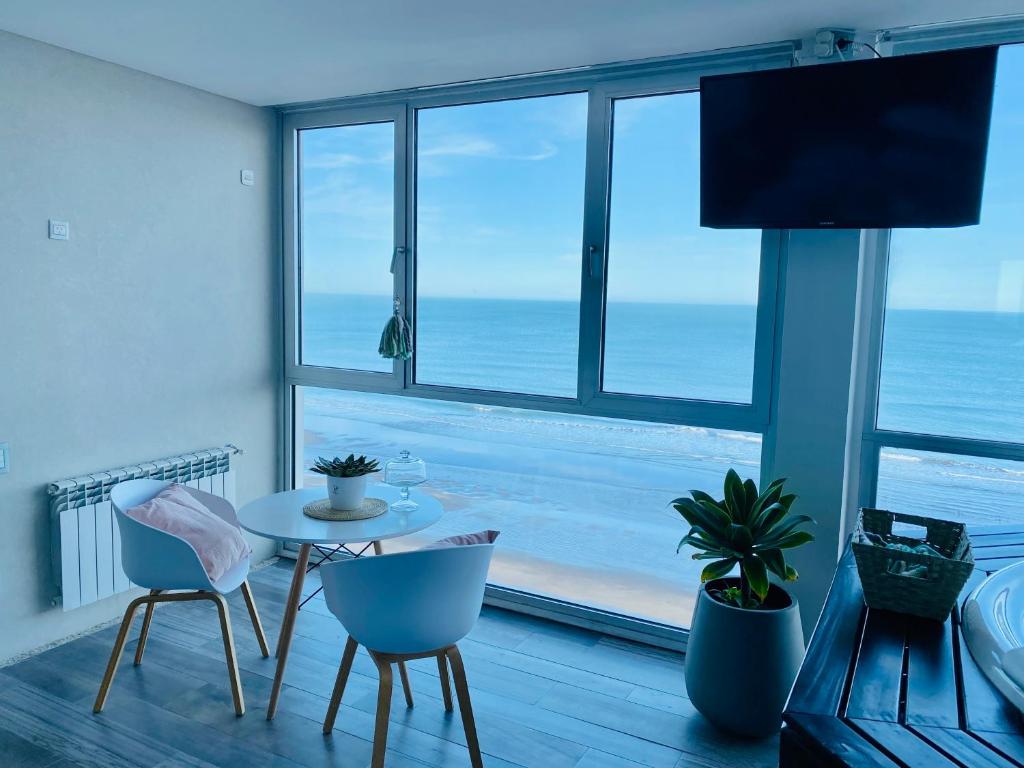 Habitación con mesa, sillas y vistas al océano. en Loft 7 piso frente al mar para 2 personas en Monte Hermoso