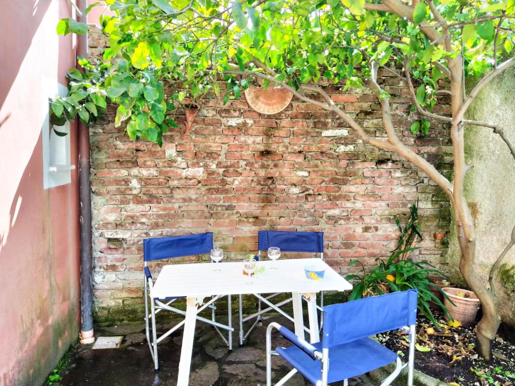 un tavolo e sedie di fronte a un muro di mattoni di Mara House a Levanto