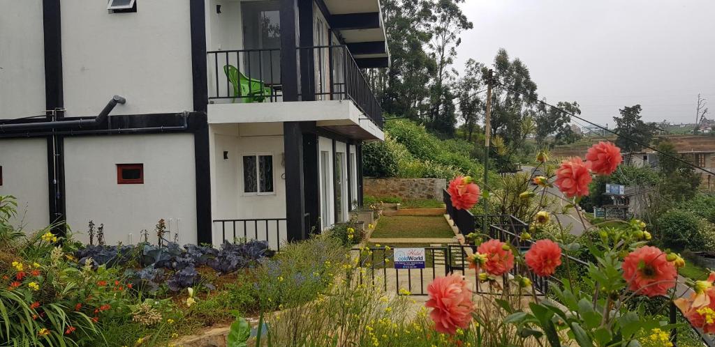 a house with a flower garden next to a building at Hotel ColdWorld in Nuwara Eliya