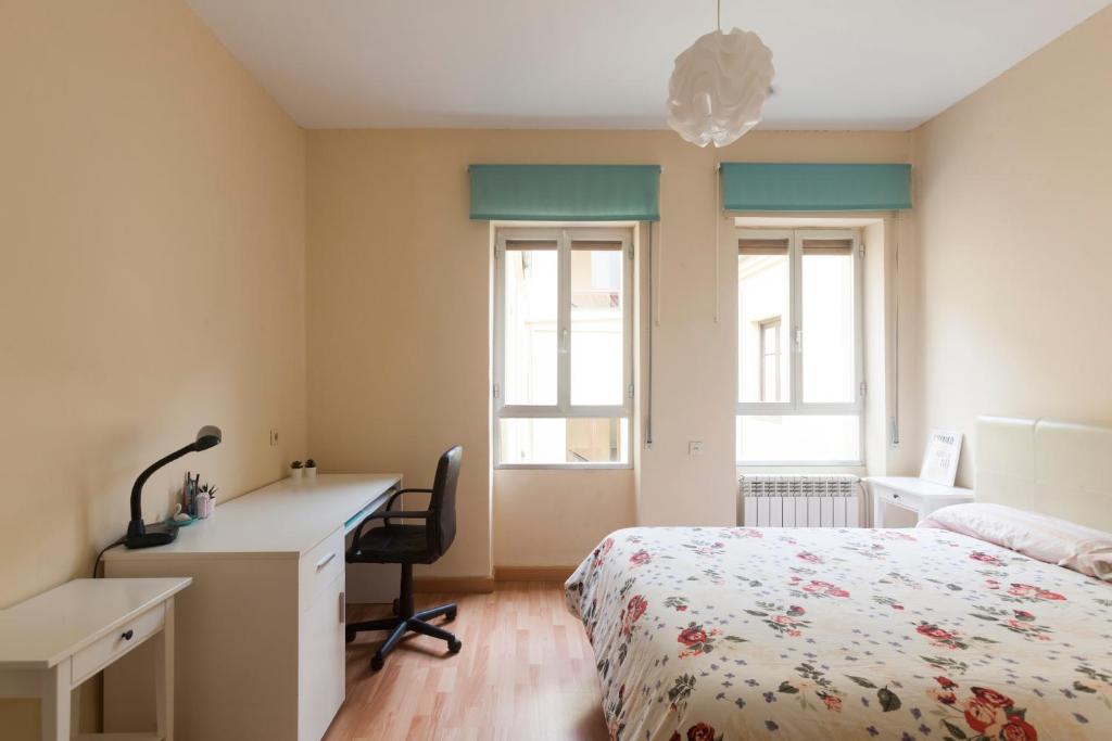 1 dormitorio con cama, escritorio y escritorio en Residencial Europa, en Salamanca