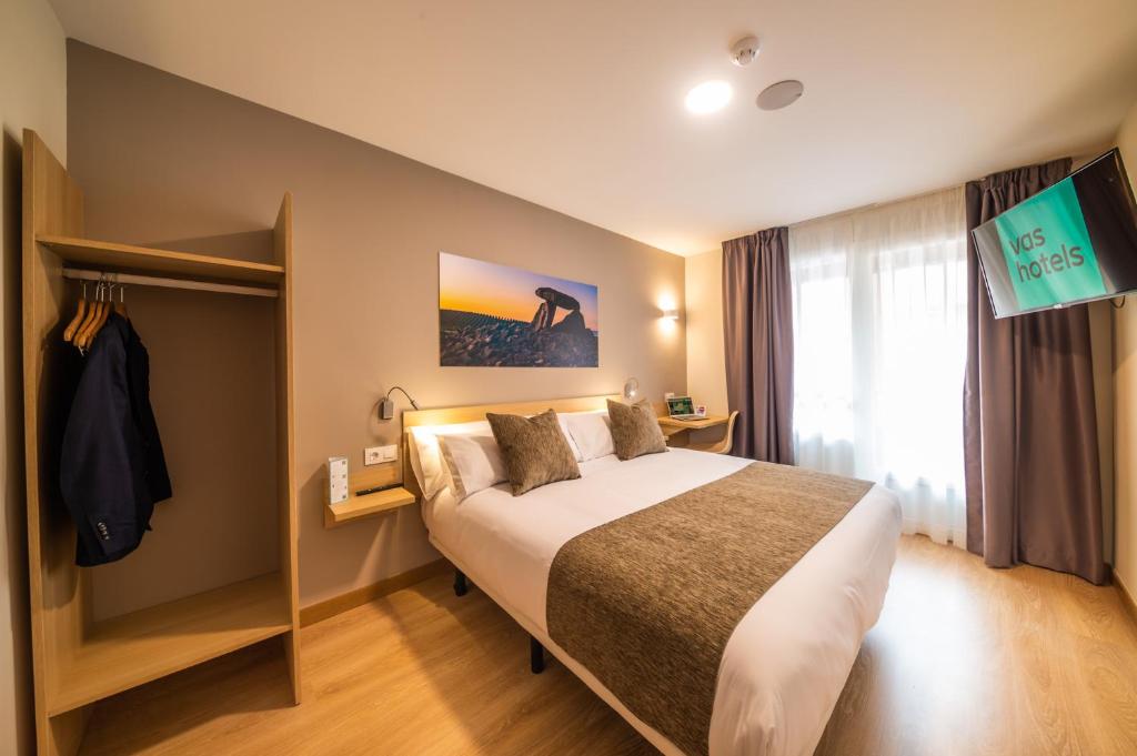 een hotelkamer met een bed en een televisie bij Hotel Vas Vitoria AutoCheckIn in Vitoria-Gasteiz