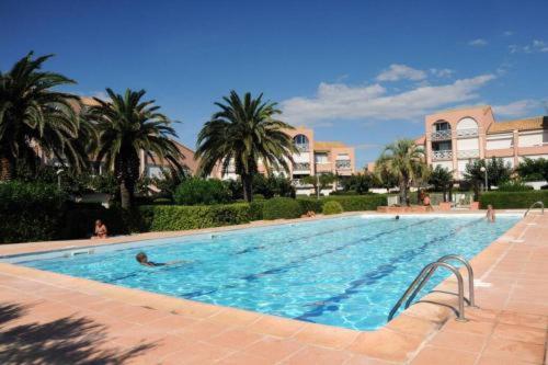 une grande piscine avec des gens dans l'eau dans l'établissement APPARTEMENT PALAVAS LES FLOTS AVEC JARDIN et PISCINE, à Palavas-les-Flots