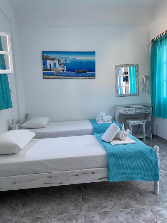 a bedroom with a bed with a blue blanket at Anna Maria Rooms Santorini in Perissa