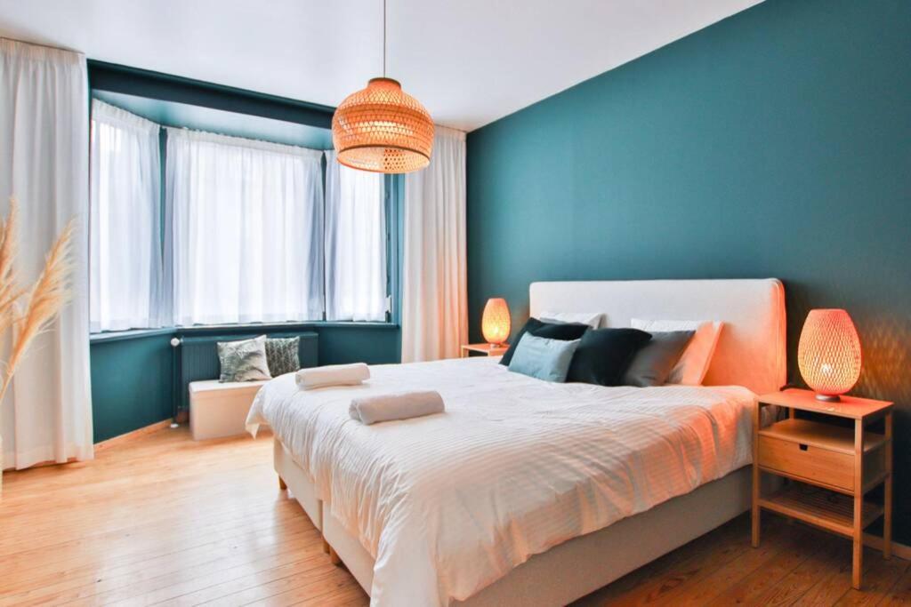 ein Schlafzimmer mit einem großen Bett mit blauen Wänden in der Unterkunft Logement L'échasseur à Jambes (NAMUR) in Namur