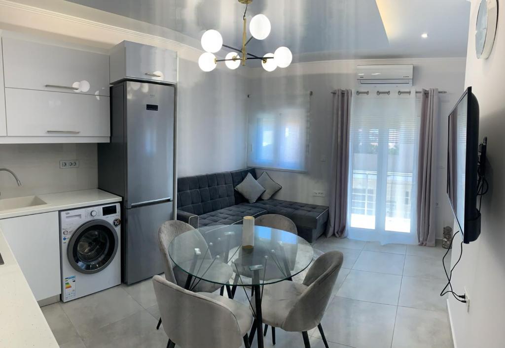 cocina y sala de estar con mesa de cristal y sillas en The Nest Apartment en Zakynthos