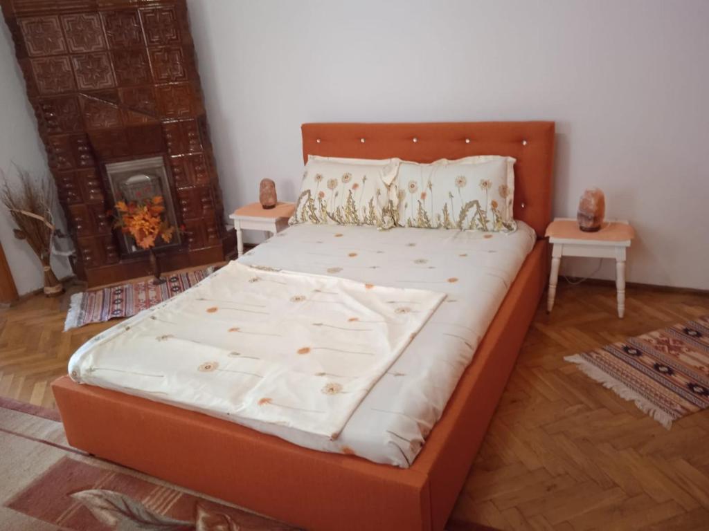 a large bed in a room with two tables at Amya - Centrul istoric in Braşov