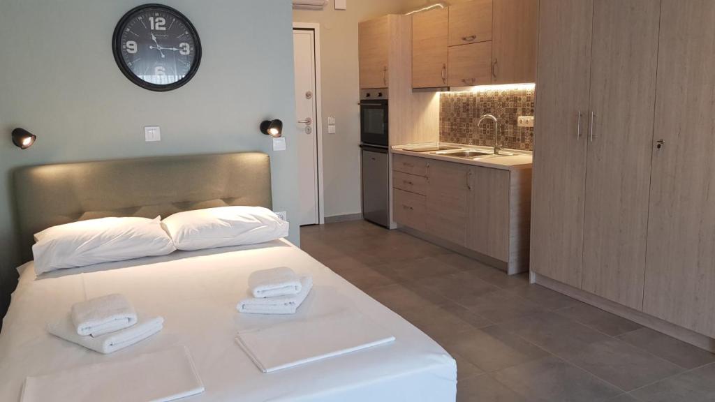 ein großes weißes Bett in einem Zimmer mit Küche in der Unterkunft Iasonas View Studio in Néa Péramos