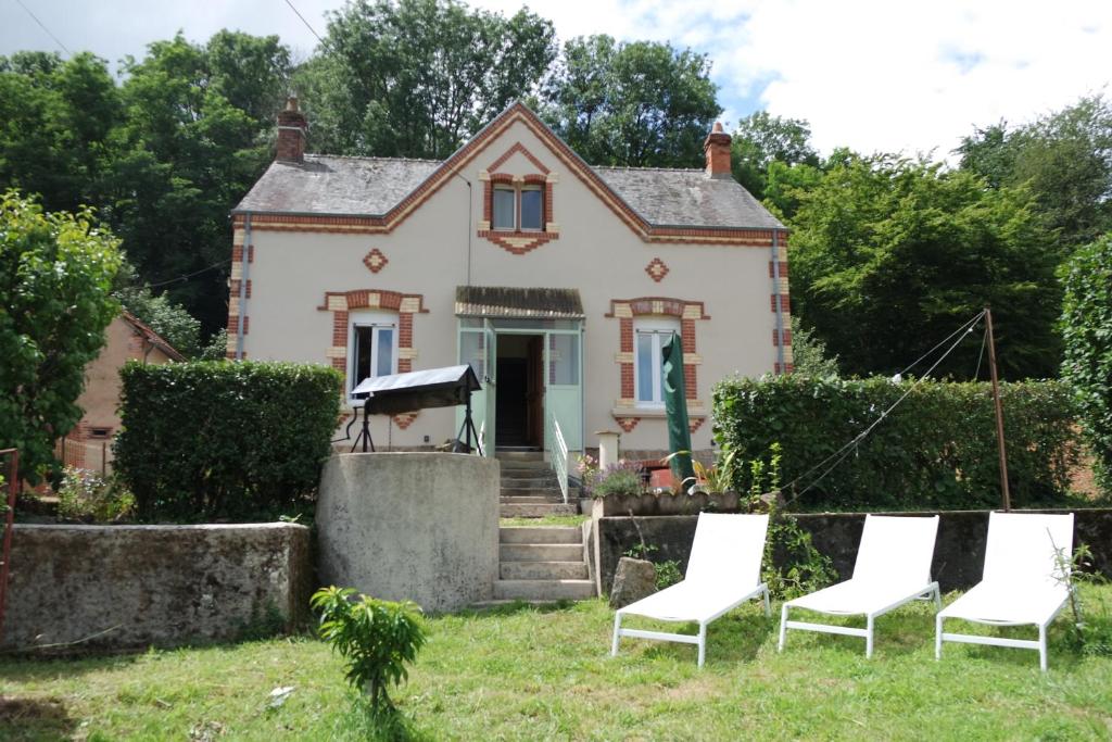 una casa con tres sillas delante en Domaine du pavillon Gîte 15 personnes, en Issy-lʼÉvêque