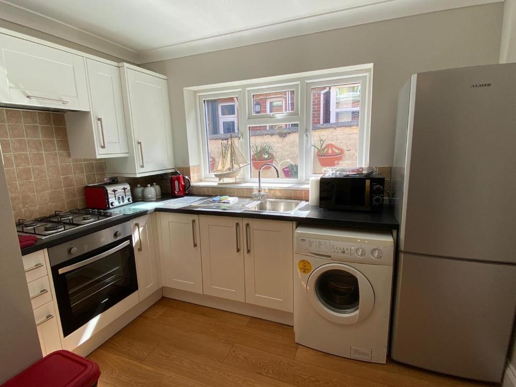 een keuken met een witte koelkast en een vaatwasser bij Sandown Seaside Apartment Ground Floor 4 in Sandown