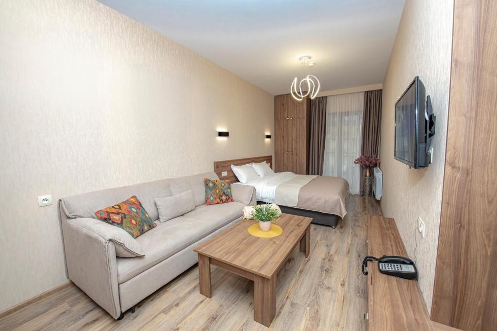 un soggiorno con divano e letto di Crystal Resort a Bakuriani