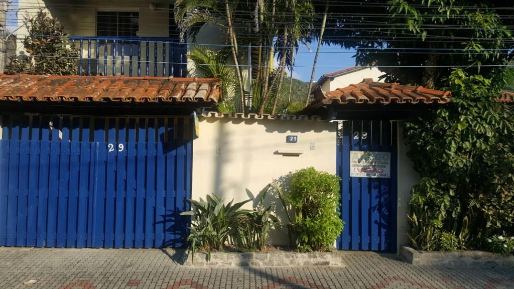 una puerta azul delante de una casa en Apartamento perto de praia Dos Anjos, en Arraial do Cabo