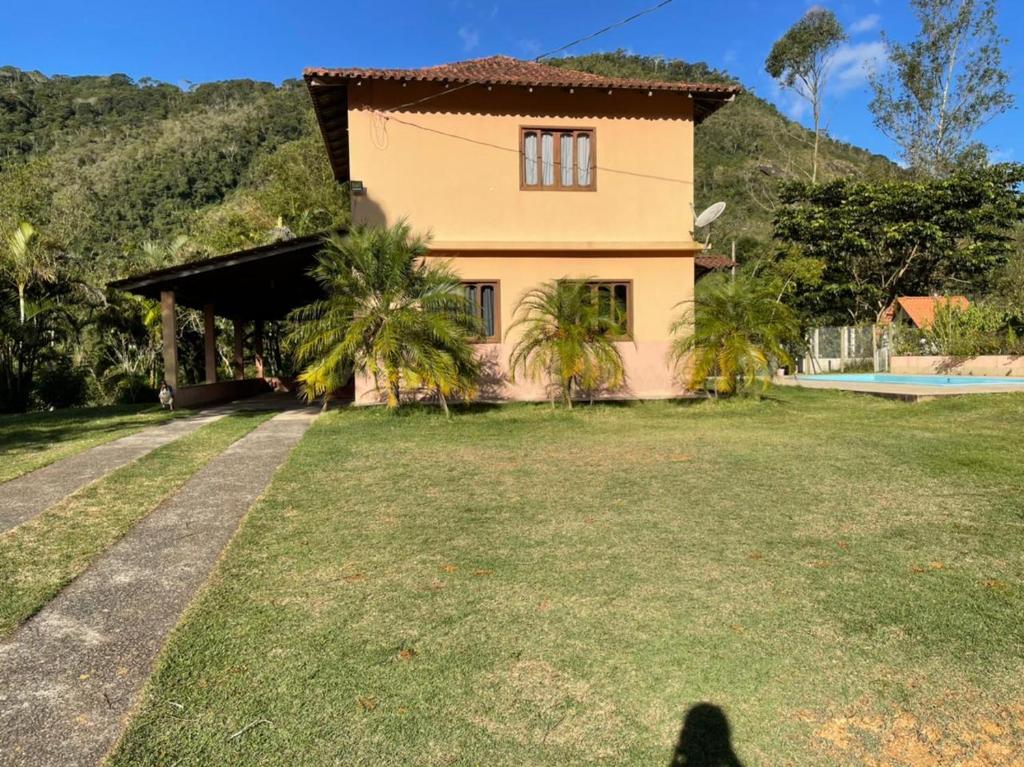 uma sombra de uma pessoa em pé em frente a uma casa em Casa de Campo com piscina e churrasqueira a 10min do Centro Domingos Martins em Domingos Martins