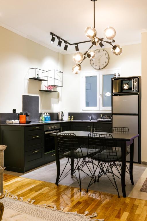 kuchnia ze stołem i zegarem na ścianie w obiekcie LUXURY #B by OTOTO w Salonikach