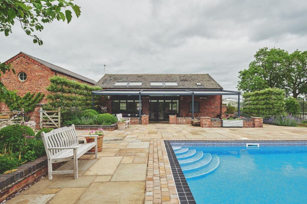 a house with a swimming pool in front of a house at Bluebell Cottage in Macclesfield
