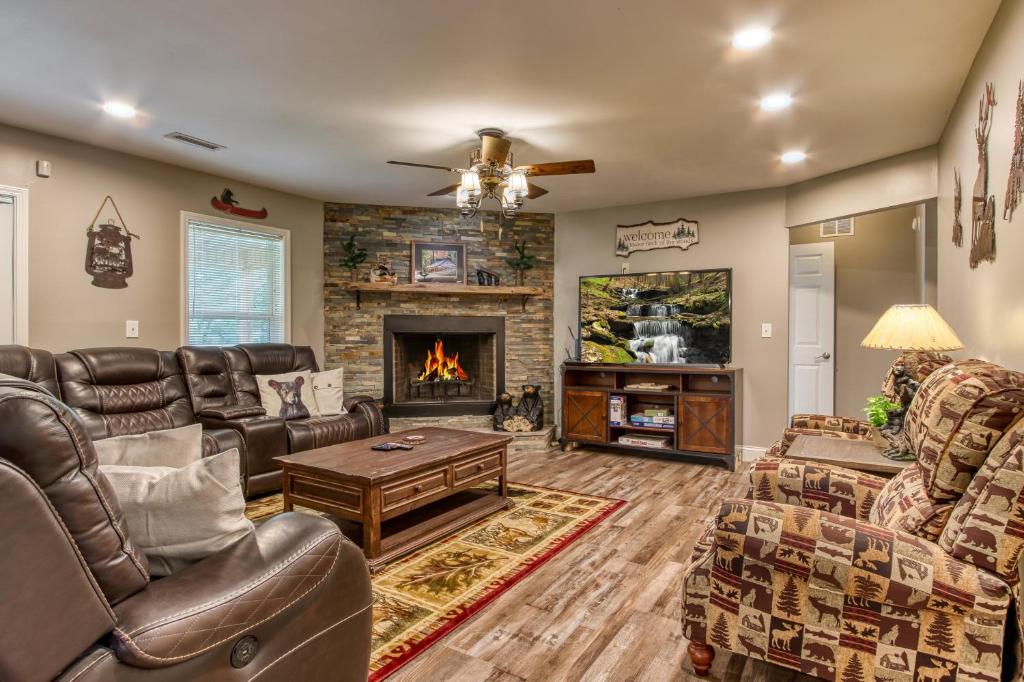 a living room with leather furniture and a fireplace at River Dance by HoneyBearCabins in Sevierville