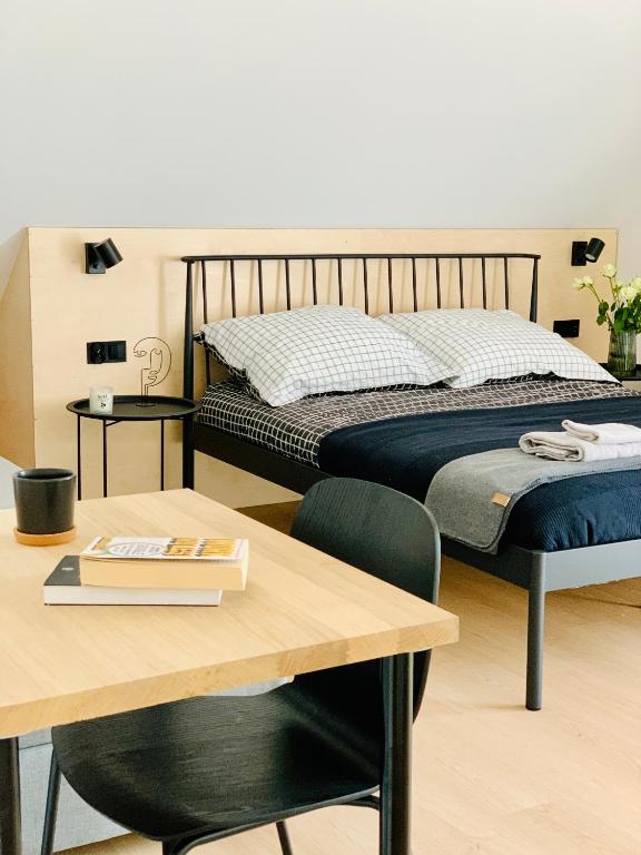 a bedroom with a bed and a table with a table sidx sidx at Apartamenty KAHOY balia pomost Kozin in Kozin
