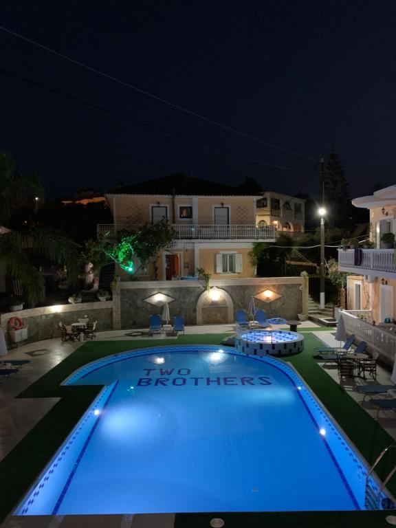 a swimming pool at night with a house in the background at Two Brothers Studios Tsilivi Zakynthos in Tsilivi