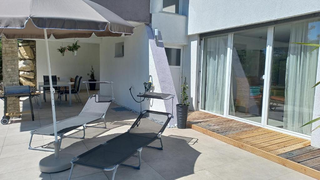 un patio con sillas, una sombrilla y una mesa en Apartment SeeYou en Keutschach am See
