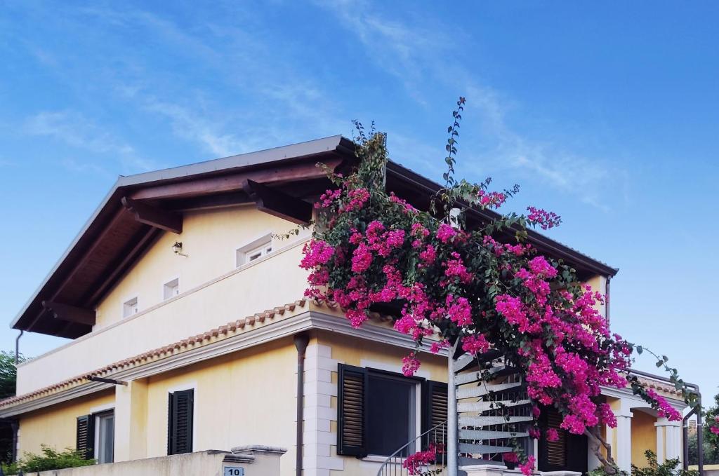 un edificio con flores a un lado. en Soggiornare a Cagliari, en Cagliari