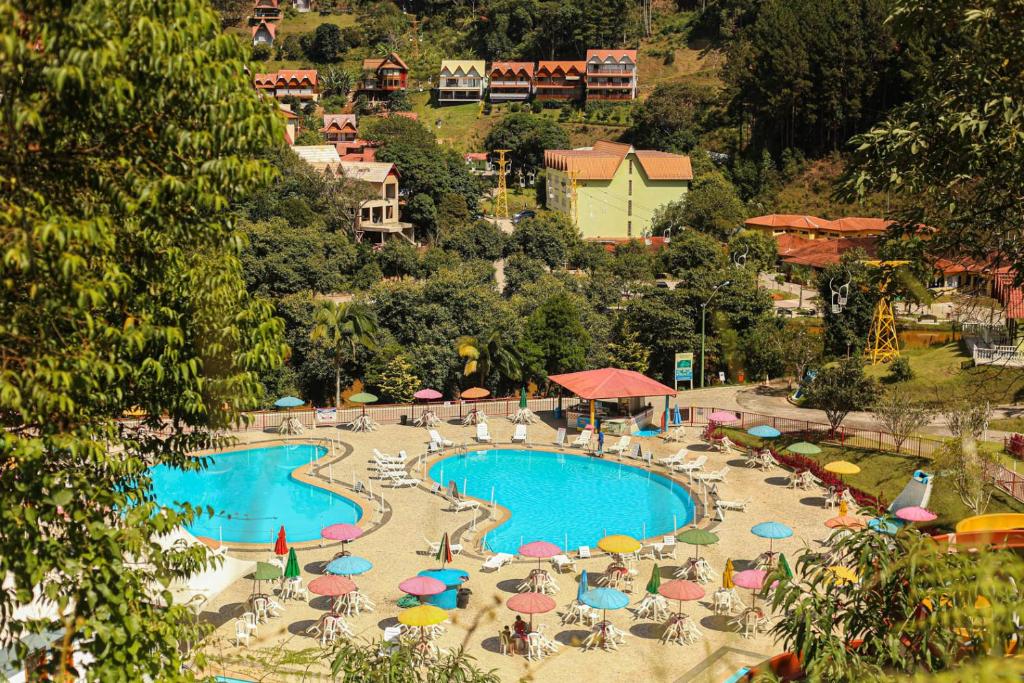 um resort com piscina, cadeiras e guarda-sóis em Hotel Fazenda China Park em Pedra Azul