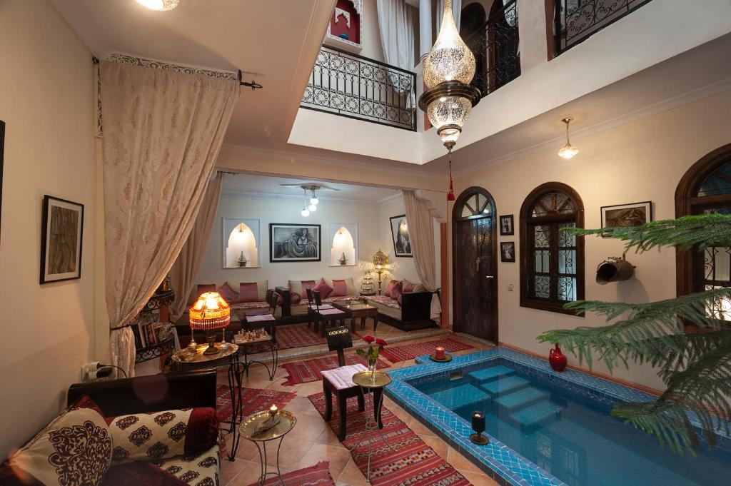una sala de estar con piscina en el medio de una casa en Riad De La Semaine, en Marrakech