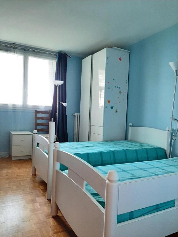 1 dormitorio con 2 literas y paredes azules en 2 bedrooms Apartment with parking Paris Neuilly, en Neuilly-sur-Seine