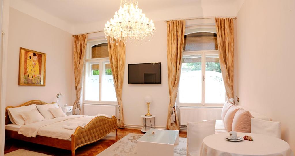 a living room with a bed and a chandelier at Apartments & Rooms Flowers in Zagreb