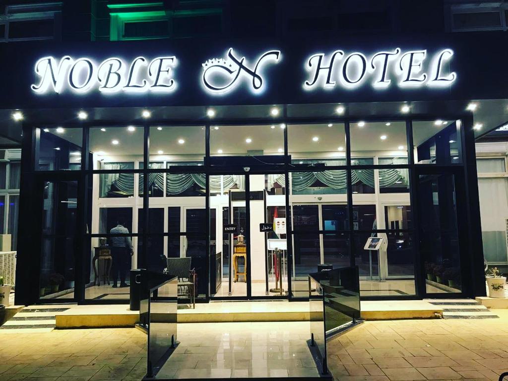 un hôtel avec un néon à l'avant dans l'établissement Noble Hotel, à Erbil