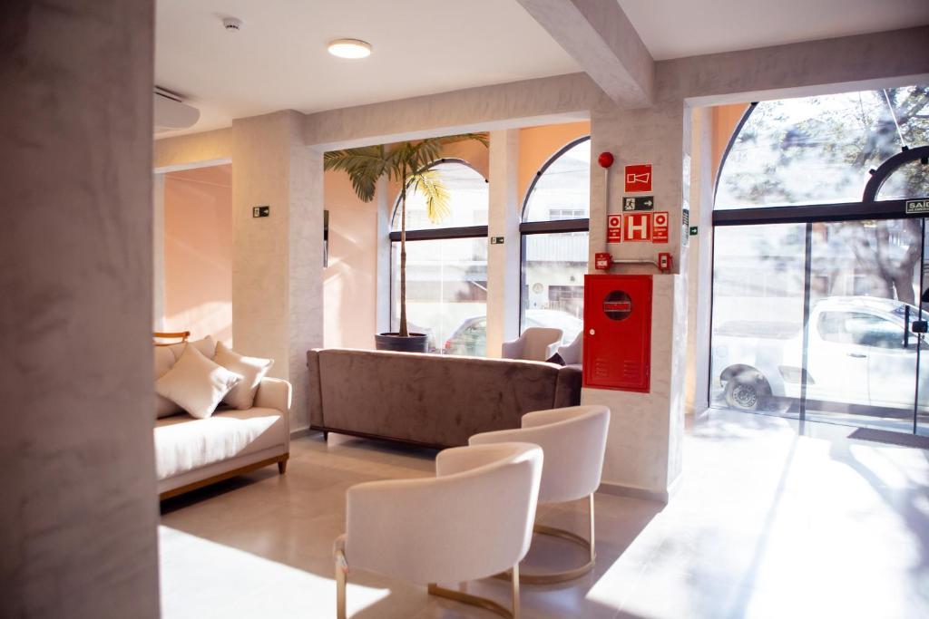 a living room with a couch and some chairs at Hotel Mamma Mia in Aparecida