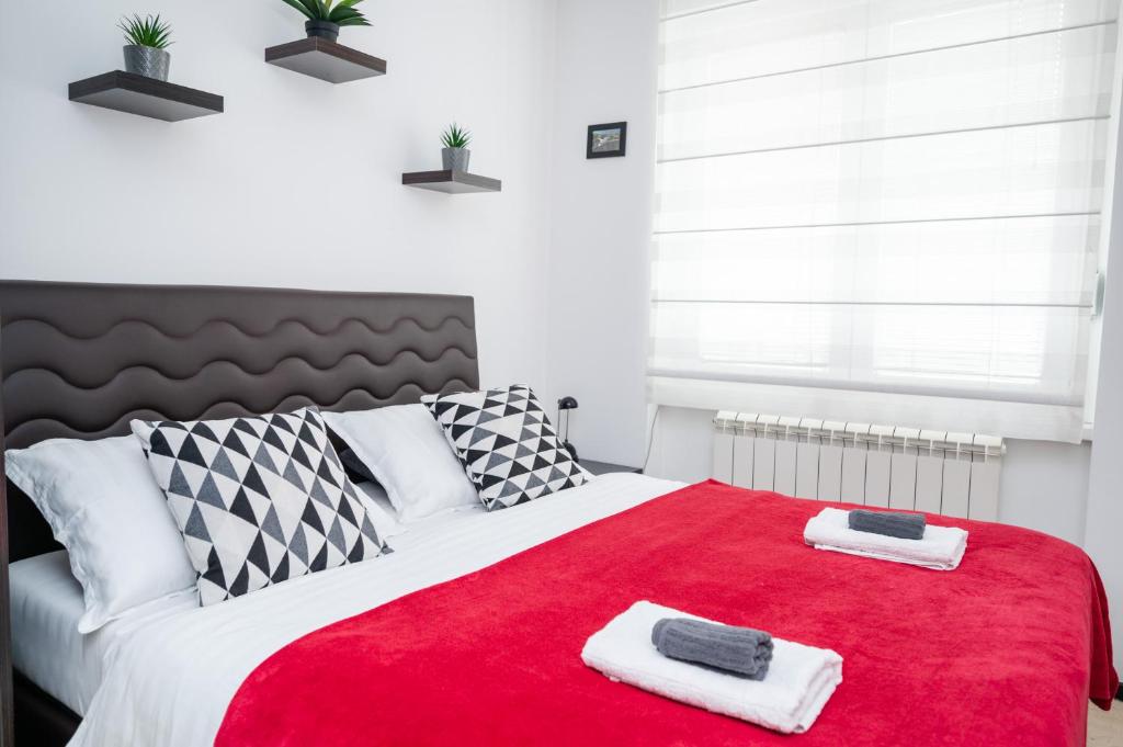 um quarto com um cobertor vermelho numa cama em Bright 1BDR Apartment in the City Center em Sarajevo