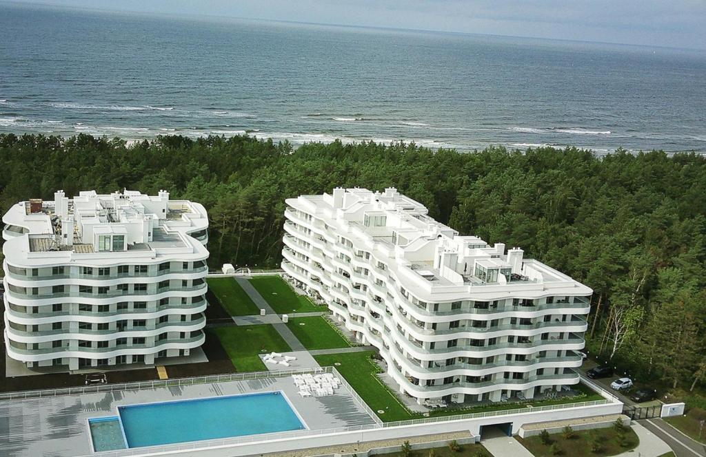 two large white buildings next to the ocean at Morska Perła in Rogowo