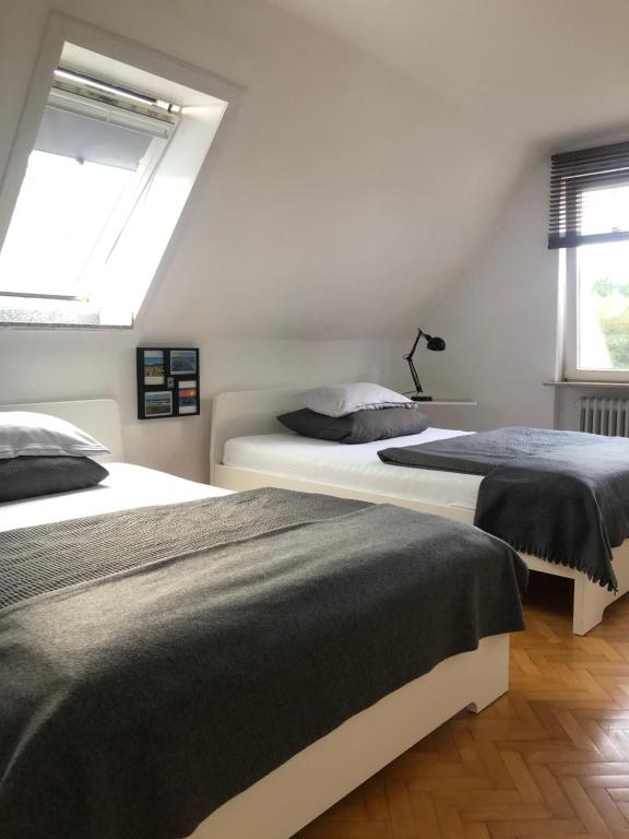 シャルボイツにあるAppartement im Grünenの白い部屋 ベッド2台 窓2つ付