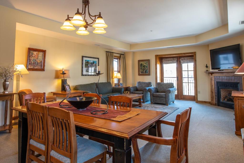 a living room with a wooden table and chairs at Two Bedroom Condo with Balcony over Mountaineer Square - Just Steps from the Slopes! condo in Crested Butte