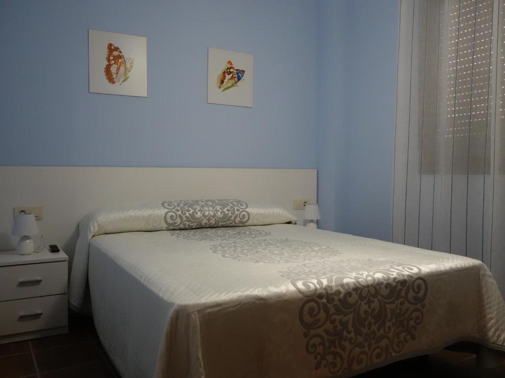 Schlafzimmer mit einem Bett mit weißer Bettwäsche und einem Fenster in der Unterkunft Casa Rural Maruja 