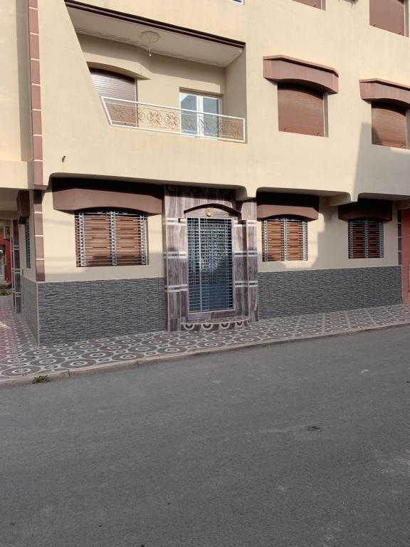 un edificio con ventanas y puertas en una calle en Appartement Mus saidia 1 en Saïdia