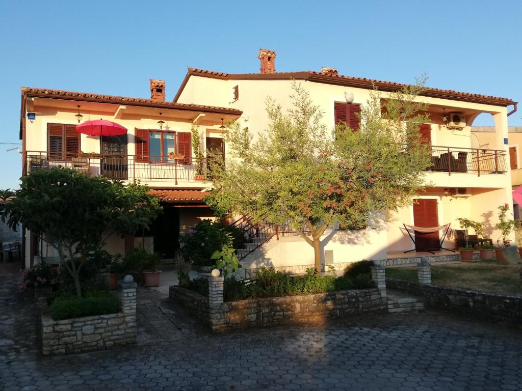 a large white house with trees in front of it at Apartment Stella in Vodnjan