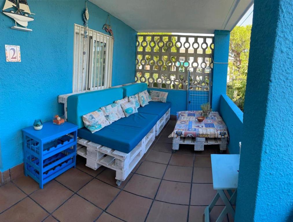 ein blaues Zimmer mit einem Bett und einem Tisch in der Unterkunft Apartamento en la playa de Calafell. Barcelona in Calafell