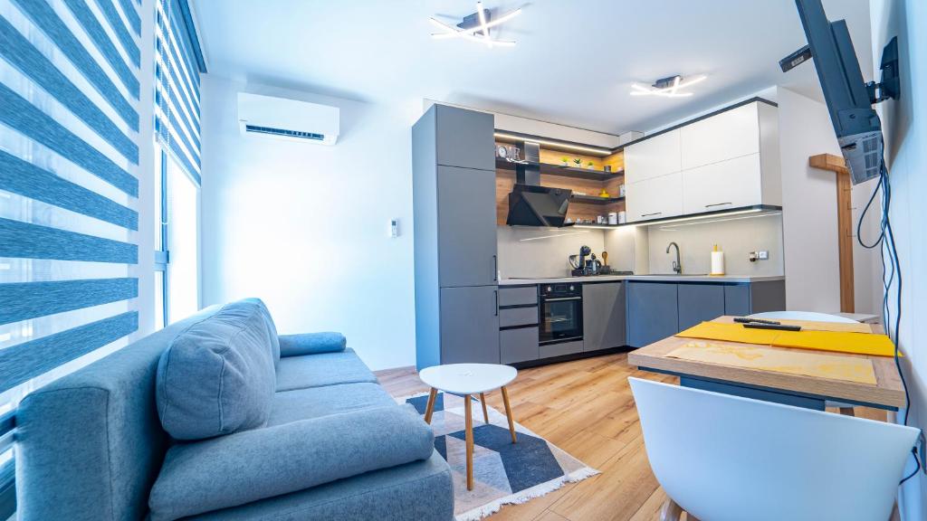sala de estar con sofá azul y cocina en Niko's Cozy Apartment, en Plovdiv