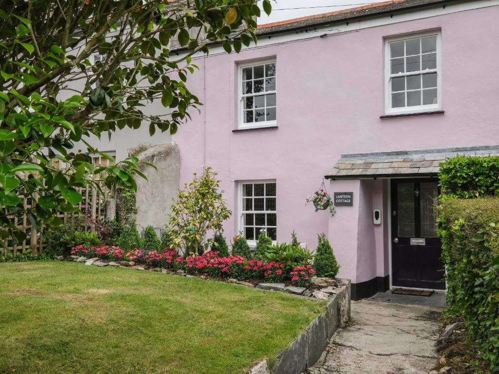 a pink house with flowers in the yard at Lantern Cottage in St Austell