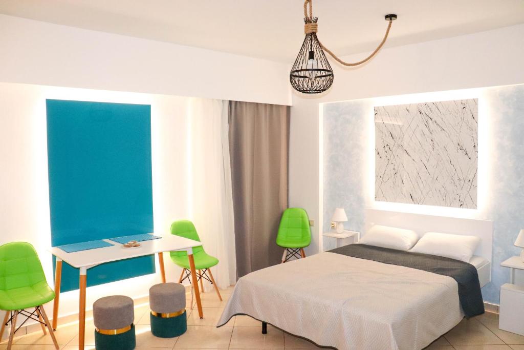 um quarto com uma cama, uma mesa e cadeiras em The Sky Yard Eclectic Studios in Ilha de Rhodes