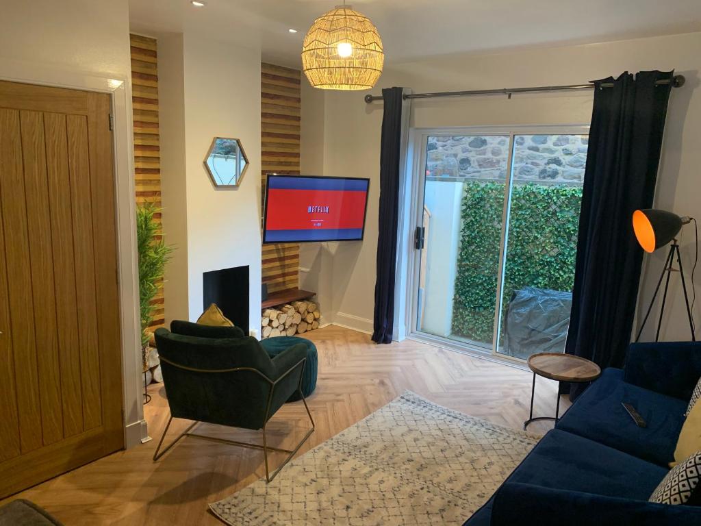 a living room with a blue couch and a tv at Skippers Retreat (with free doorstep parking) in North Berwick