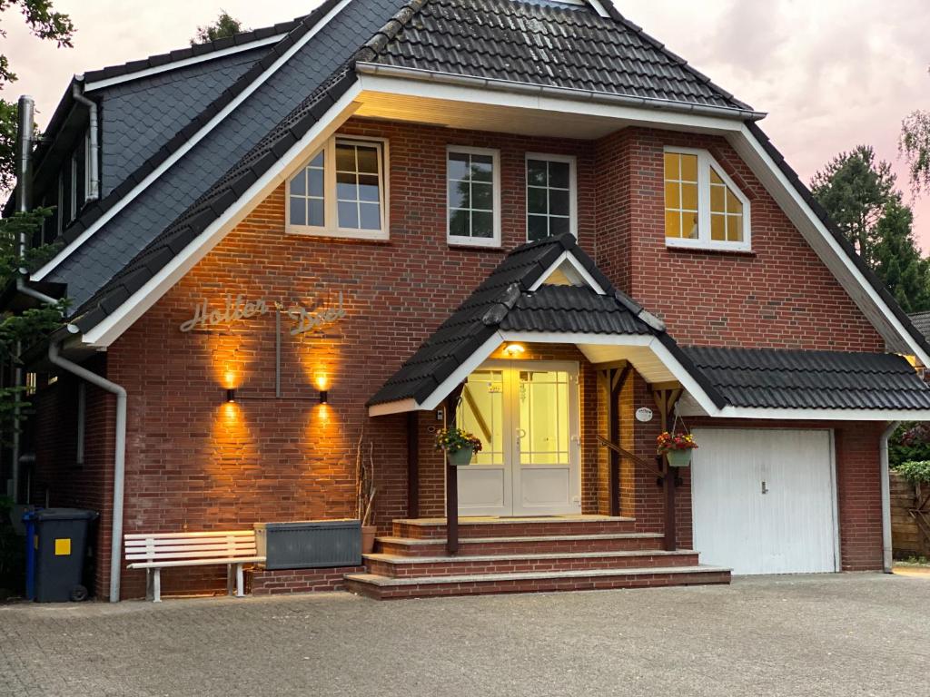 una casa de ladrillo marrón con un banco delante de ella en Pension Holter Deel en Cuxhaven