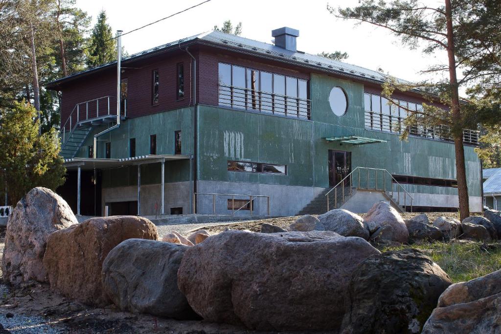 ein Gebäude mit großen Felsen davor in der Unterkunft Dirhami Guesthouse in Dirhami