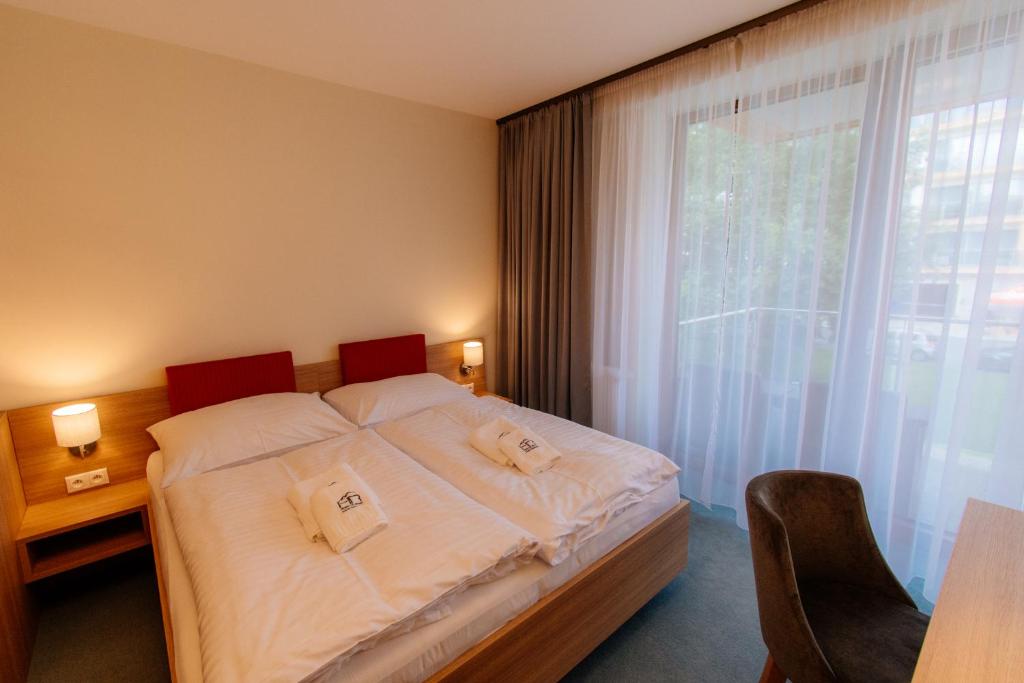 1 dormitorio con cama y ventana grande en Apartmán C317 Hrebienok Resort 2 en Stary Smokovec
