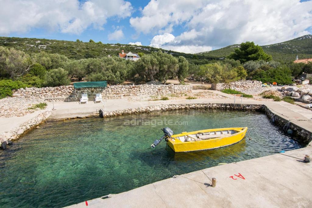 un bateau jaune dans un bassin d'eau dans l'établissement House Motar, à Ždrelac