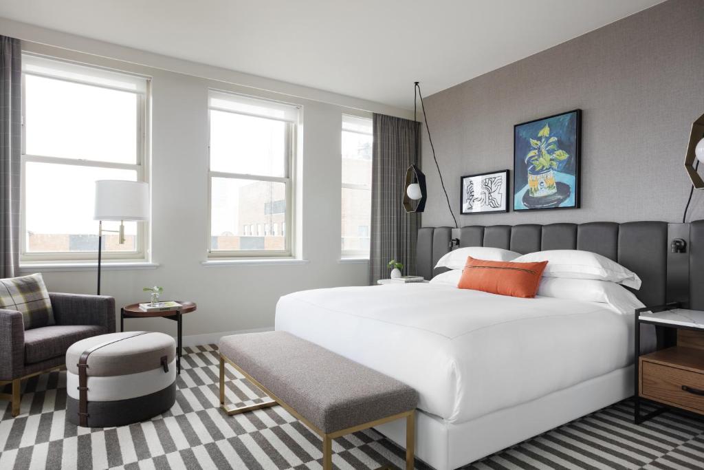 um quarto com uma grande cama branca e uma cadeira em Kimpton - Harper Hotel, an IHG Hotel em Fort Worth